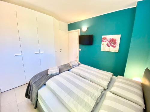 a bedroom with a bed and a green wall at Tower 44 in Luino