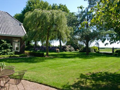 a yard with tables and chairs and a tree at Landgoed Wittelte Dwingeloo in Wittelte