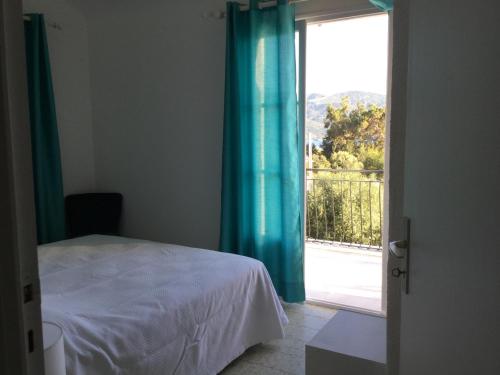 une chambre avec un lit et une porte coulissante en verre dans l'établissement Villa indépendante climatisée Tiuccia Bord de mer, à Casaglione