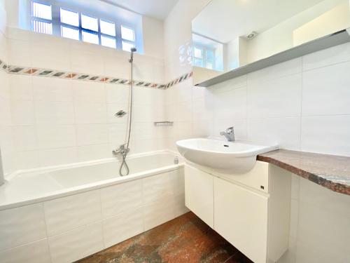 a white bathroom with a sink and a bath tub at Tower 44 in Luino