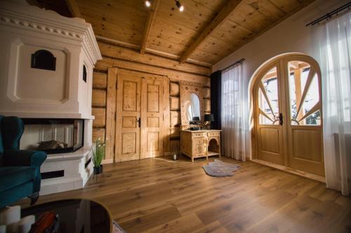 a living room with a wooden ceiling and a door at Apartamenty Stare Izby in Poronin