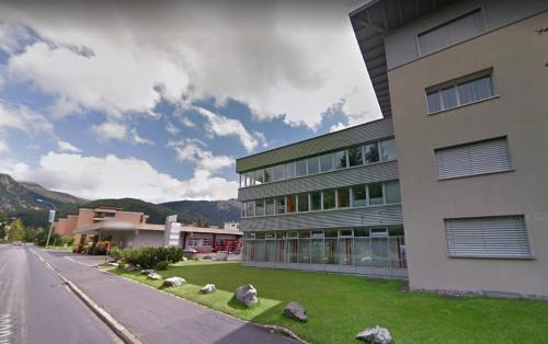 a building on the side of a street next to a road at Davos Lodge by Quokka 360 - practical apartment for skiers in Davos