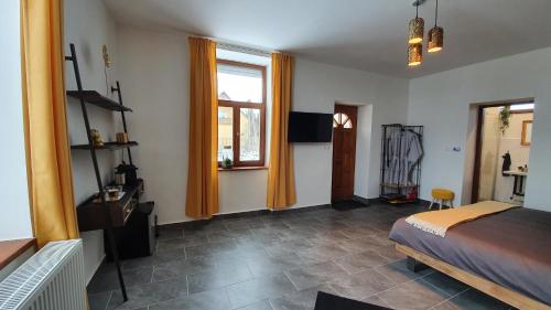 a bedroom with a bed and a window and a television at Tisza White House in Tiszaszőlős