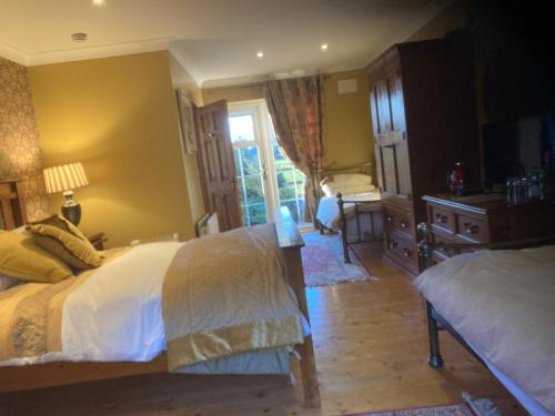 a bedroom with two beds and a desk and a window at Evergreen Bed & Breakfast in Swords