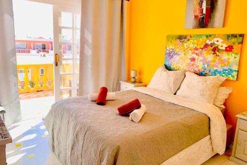 a bedroom with a large bed with red pillows on it at NEW Apartamento Caleta,Relax, Pool, Terrace, Wifi in Caleta De Fuste