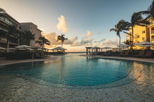 a swimming pool at a resort with palm trees at Dreams Jade Resort & Spa - All Inclusive in Puerto Morelos
