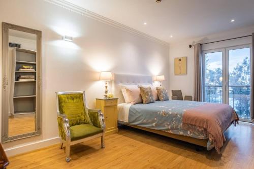 フンシャルにあるFunchal Center Apartment Iのベッドと椅子と窓のある寝室