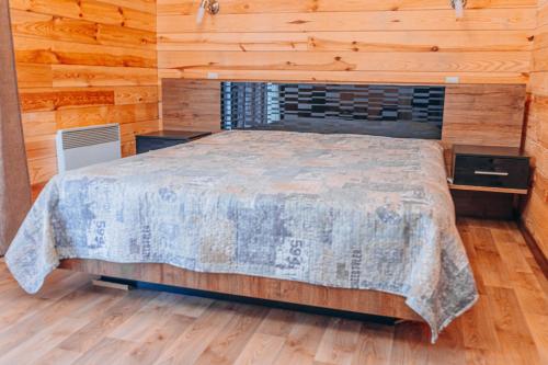 a bedroom with a bed in a wooden cabin at Log House Savin in Savin