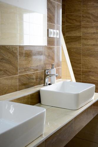 a bathroom with a white sink and a mirror at Sweety-Apartman in Mátészalka