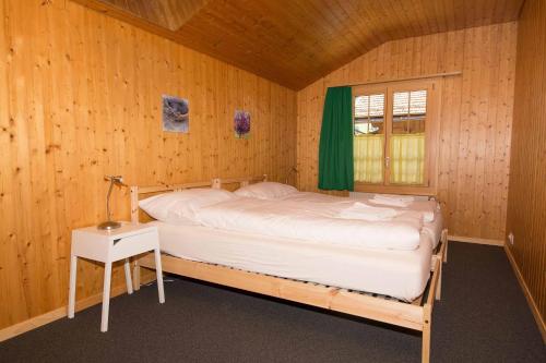 Schlafzimmer mit einem Bett, einem Tisch und einem Fenster in der Unterkunft Im Zentrum OG in Adelboden