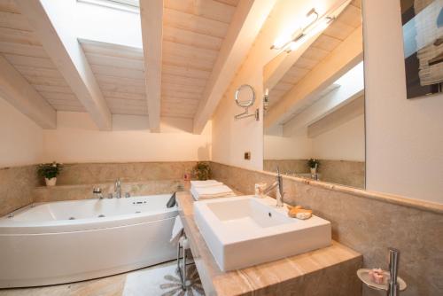 a bathroom with a tub and a sink and a bath tub at Villa Malcesine in Malcesine