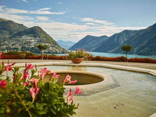 a swimming pool with a view of mountains and a lake at Villa Principe Leopoldo in Lugano