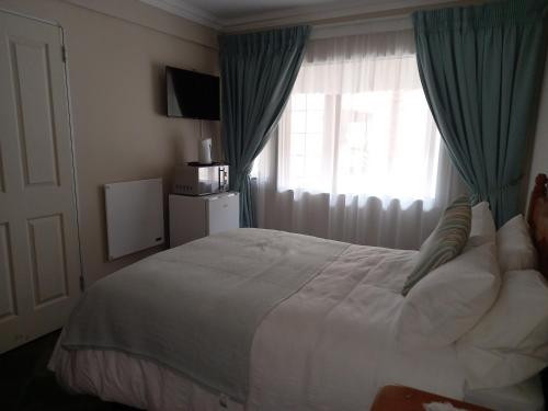 a bedroom with a large bed and a window at Troas Boutique hotel in Vanderbijlpark