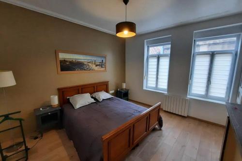 ein Schlafzimmer mit einem großen Bett und zwei Fenstern in der Unterkunft Idéal vieille Ville de Boulogne La Boulonnaise ! in Boulogne-sur-Mer