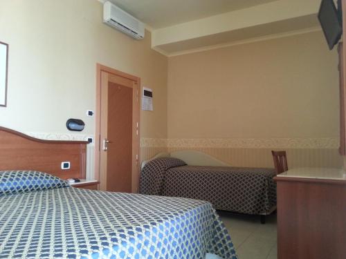 a hotel room with a bed and a window at Hotel Grifone in Rimini