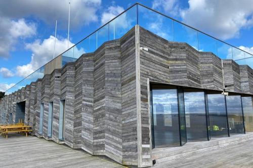 a building with glass windows and a wooden deck at The Old Queens Stable on Sea in Hollington