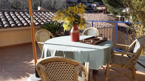 una mesa con sillas y un jarrón con flores. en Appartement Maison Croisette, en Sainte-Maxime