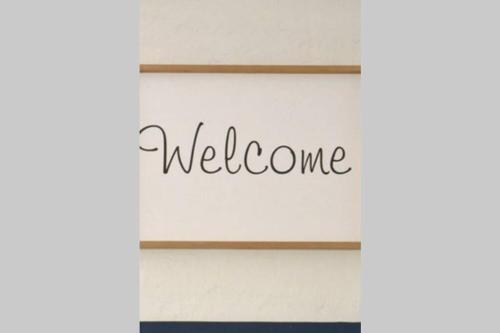 a sign that says welcome on a white house at 12 Settler Sands Beachfront cottage with sea view in Port Alfred
