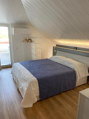 Un dormitorio con una cama grande con suelo de madera. en RESIDENZA VILLA LEONIDA, en SantʼAmbrogio di Valpolicella