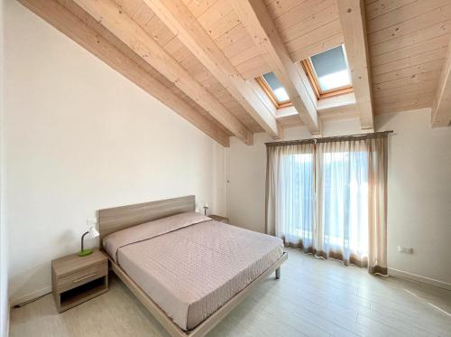 a bedroom with a bed and a large window at Residence Treporti - Carraro Immobiliare - Family Apartments in Cavallino-Treporti