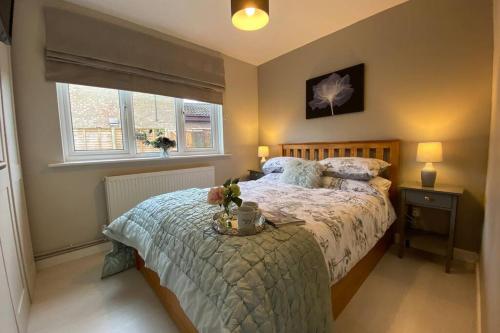 1 dormitorio con cama y ventana en Modern and spacious open plan bungalow, en Felixstowe
