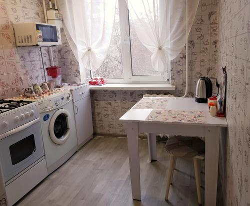 a kitchen with a washing machine and a table at Apartment Home comfort in Nikolaev in Mykolaiv