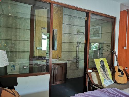 uma casa de banho com uma banheira, um lavatório e uma guitarra em Serendib Village Guest House em Negombo