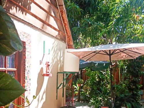 - une terrasse avec un parasol dans l'établissement Cabañas Rústicas El Benny by Rotamundos, à Loreto
