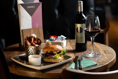 a table with a sandwich and a glass of wine at The Temperance Inn, Ambleside - The Inn Collection Group in Ambleside