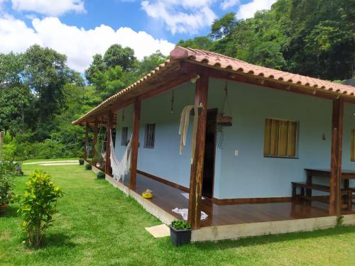 ein kleines weißes Haus mit einem Holzdach in der Unterkunft Chácara Cantinho do Ipê in Marechal Floriano