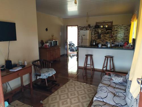 ein Wohnzimmer mit einem Schreibtisch und einer Küche in der Unterkunft Chácara Cantinho do Ipê in Marechal Floriano
