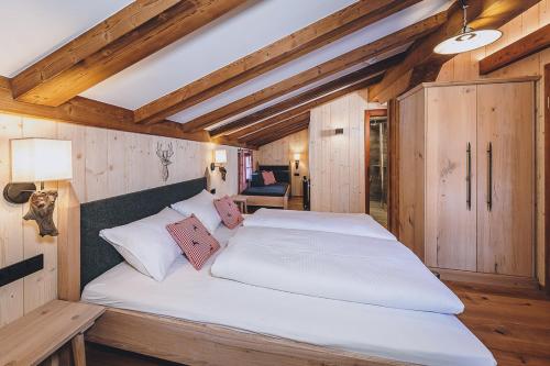 a bedroom with a large white bed in a room at AlpenOase Sonnhof in Saalbach Hinterglemm