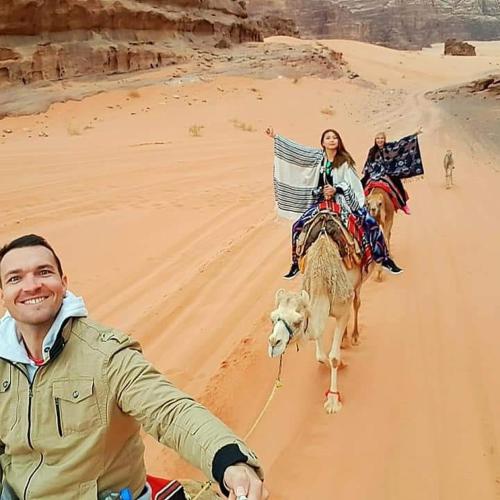 two people riding on camels in the desert at WADI RUM STAR WARS CAMP in Wadi Rum