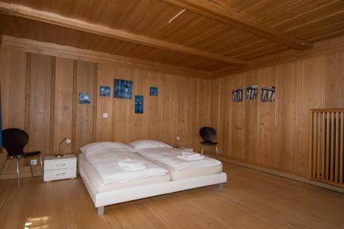 a bedroom with a bed and two chairs in it at Im Zentrum in Adelboden