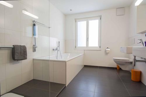 a white bathroom with a sink and a toilet at Im Zentrum in Adelboden