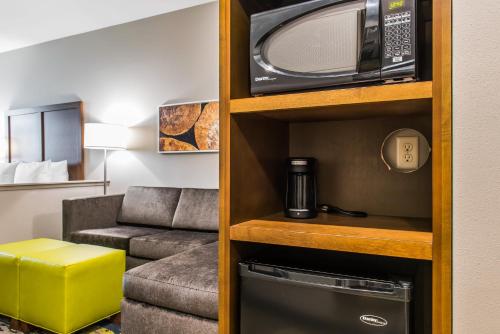 a living room with a microwave and a couch at Comfort Inn & Suites Valdosta in Valdosta