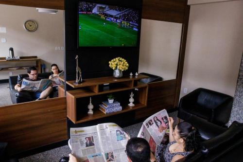 伊塔佩魯納的住宿－Hotel Albinos，一群人在客厅观看足球比赛