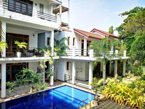 an external view of a building with a swimming pool at Serendib Village Guest House in Negombo