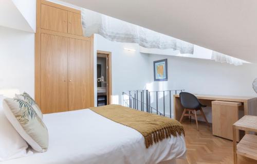 sypialnia z białym łóżkiem, biurkiem i biurkiem w obiekcie Apartamento Barquillo Duplex en Madrid w Madrycie