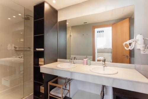 łazienka z dwiema umywalkami i dużym lustrem w obiekcie Apartamento Barquillo Duplex en Madrid w Madrycie