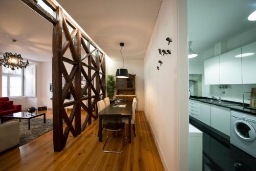 a kitchen and dining room with a wooden table in a room at Fanqueiros 204 - Old Town in Lisbon