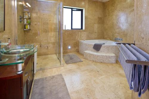 a bathroom with a shower and a tub and a sink at Moorepark West House in Fermoy