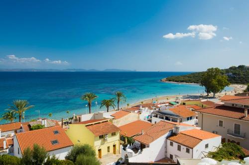 a view of a town with a beach and the ocean at Lu' Hotel Maladroxia in SantʼAntìoco