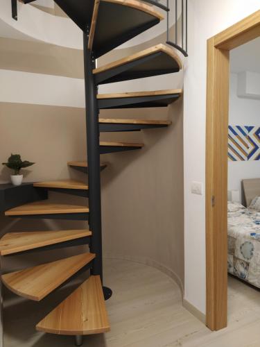 a spiral staircase in a room with a bed at Appartamenti Il Cerbiatto in Cavedago