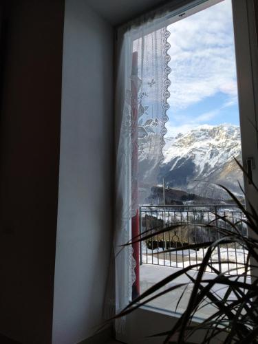 a window with a view of a snow covered mountain at Appartamenti Il Cerbiatto in Cavedago