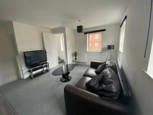 ein Wohnzimmer mit Sofa und Fernseher in der Unterkunft Doncaster Furnished House For Short Lets in Mexborough