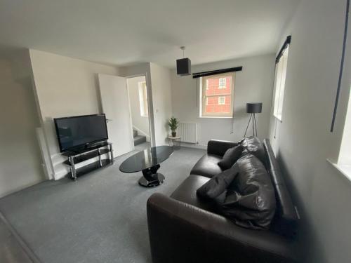 a living room with a couch and a tv at Doncaster Furnished House For Short Lets in Mexborough