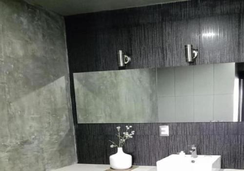 La salle de bains est pourvue d'un lavabo et d'un vase de fleurs. dans l'établissement ESDUMA HK HOTEL Pachuca, à Pachuca