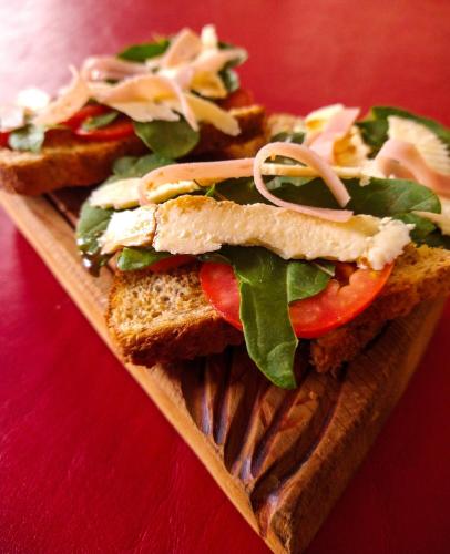 a sandwich on a wooden plate on a table at Hotel de la Linda in Salta