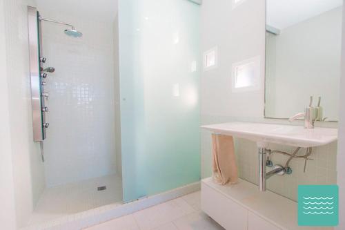 uma casa de banho com uma cabina de duche em vidro e um lavatório. em VILLA Traviata em Benissa